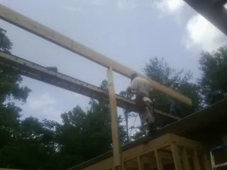 Carpenter setting a ridge beam over a new addition frame — Ice Dam Removal by Roofing Brothers in Merrill